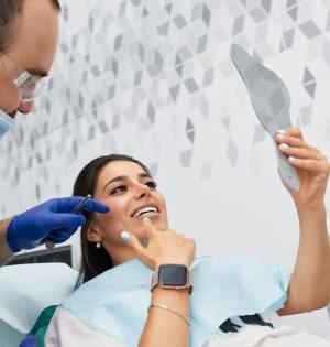 Cosmetic Dentistry happy male dentist showing work plan to woman patient at dental clinic office for cosmetic dentistry.